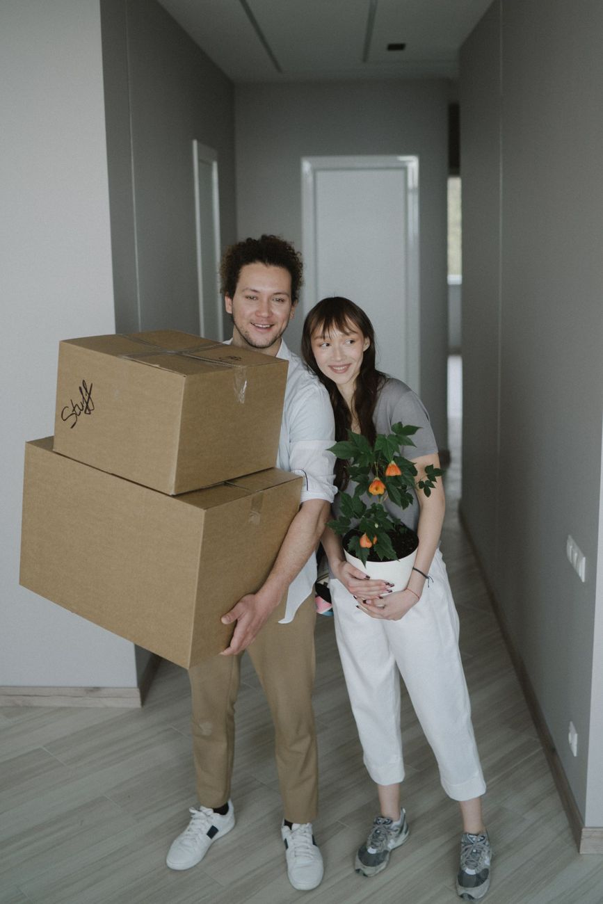 Pareja entrando con cajas en su piso nuevo